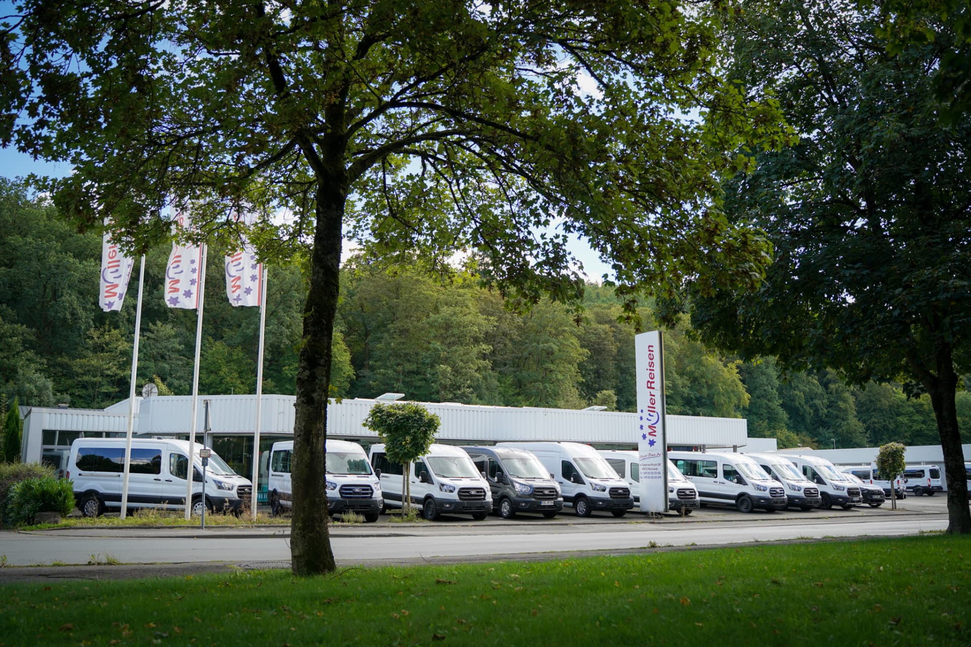 Fahrzeugflotte von Müller Mobility vor dem Betriebsgelände in Meschede